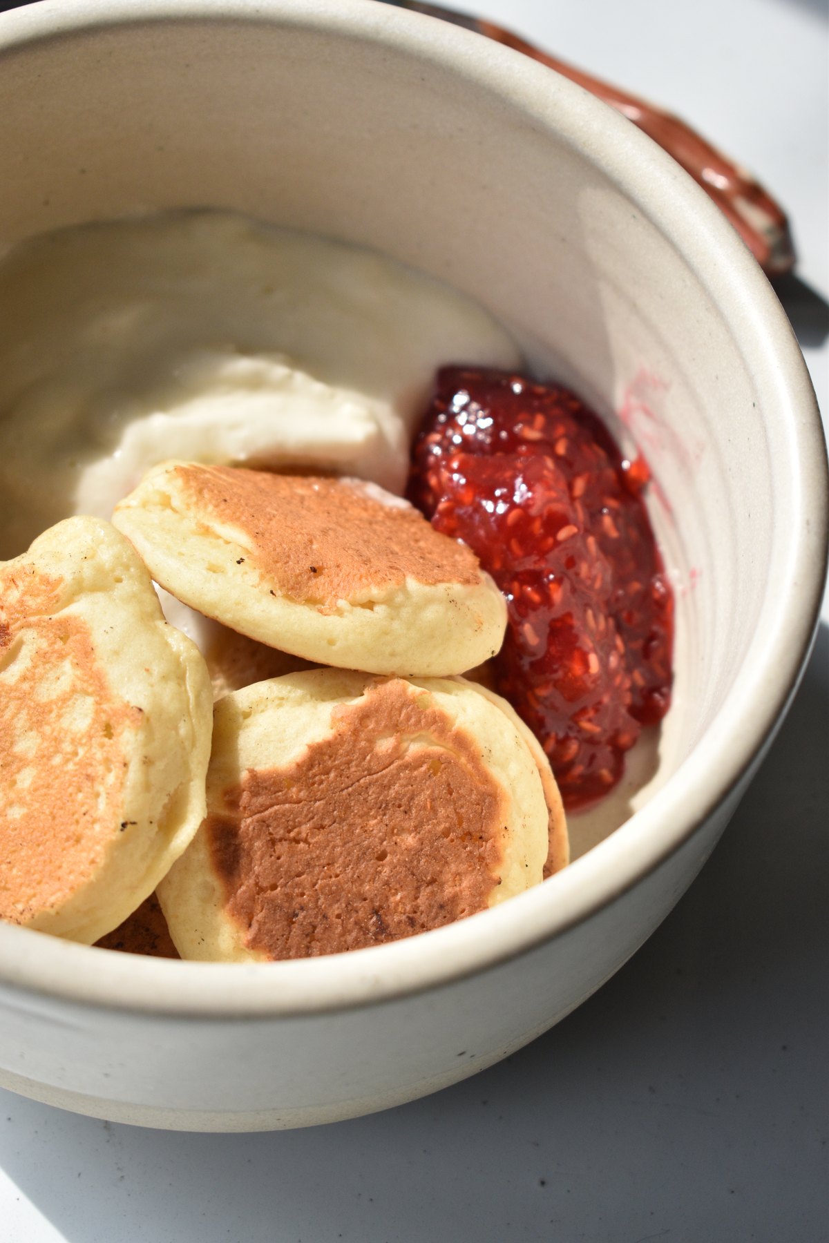 Platillo dulce de mini hot cakes con crema y conserva