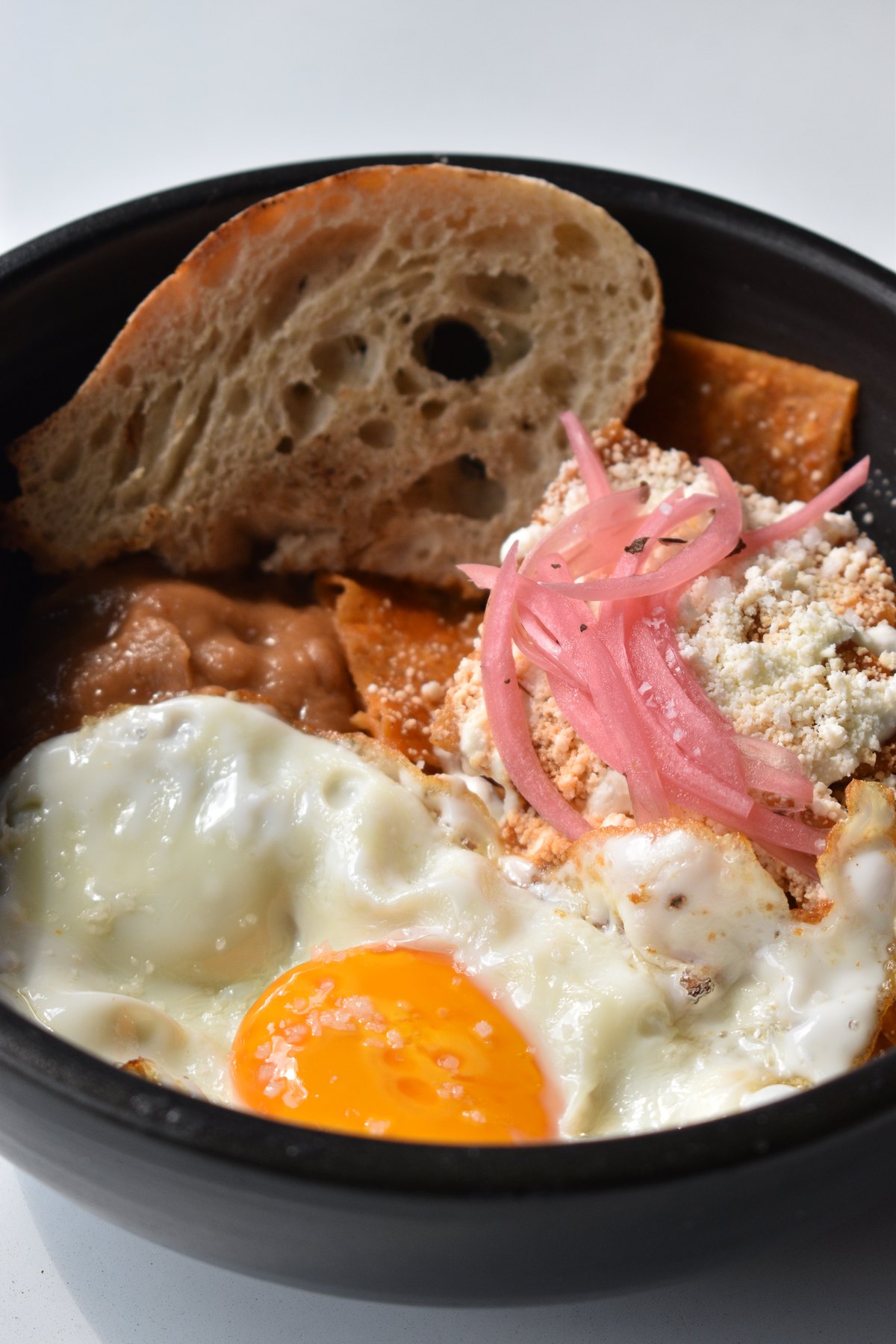 Plato de brunch con huevo, pan y cebolla encurtida
